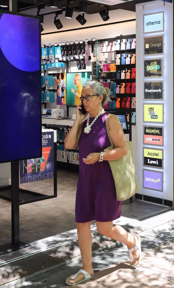 Archivo - Una mujer pasa por una tienda Phone House, a 26 de julio de 2022, en Madrid (España). Archivo