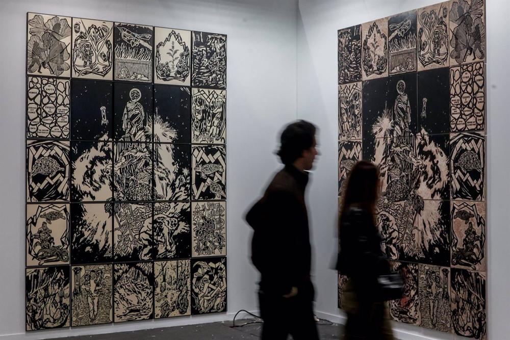 Dos personas observan la obra de Clara Carvajal en el estand de Espacio Valverde en la 30 edición de la Feria Estampa, en IFEMA Madrid Dos