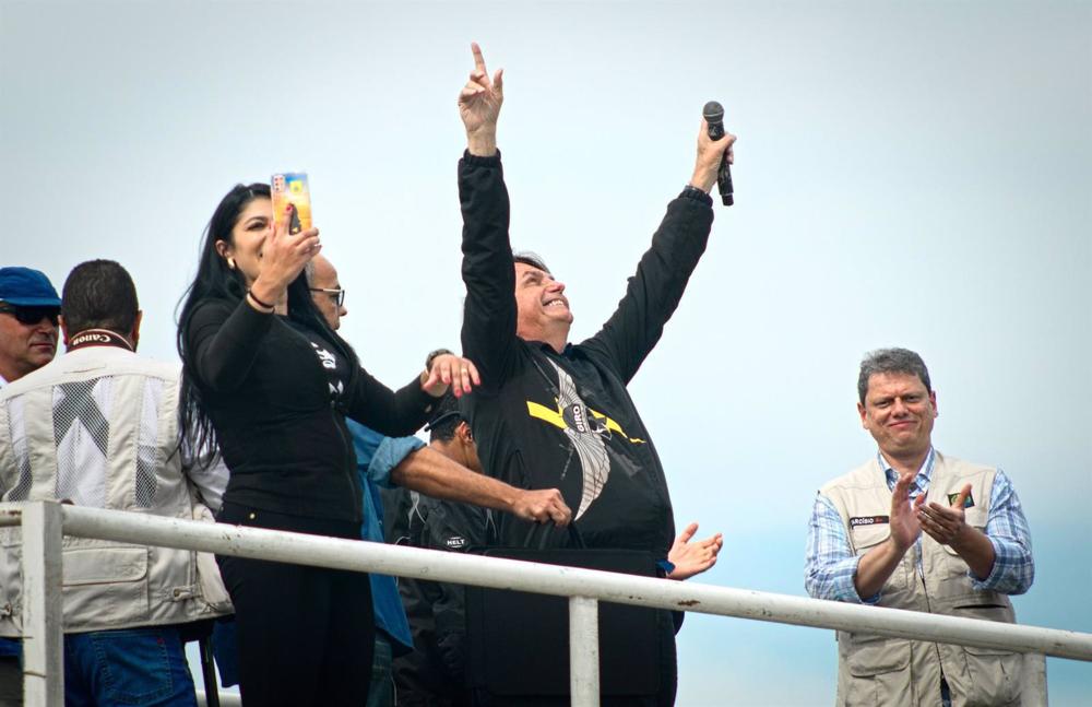 Archivio - Il presidente brasiliano Jair Bolsonaro, al centro, a braccia alzate, mentre l'ex ministro delle Infrastrutture Tarcísio Gomes de Freitas (R) lo applaude. Archivio