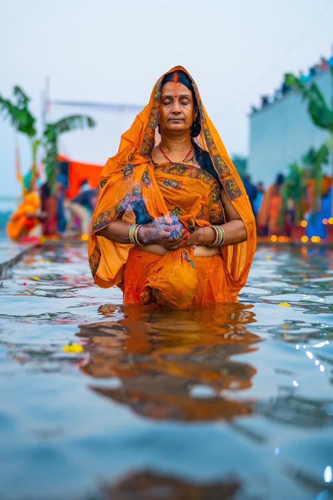30 ottobre 2022, India, Ahmedabad: devoti indù eseguono rituali al tramonto sulle rive del fiume Sabarmati nell'ambito del festival Chhath Puja. Foto: Saurabh Sirohiya/ZUMA Press Wire/dpa 30