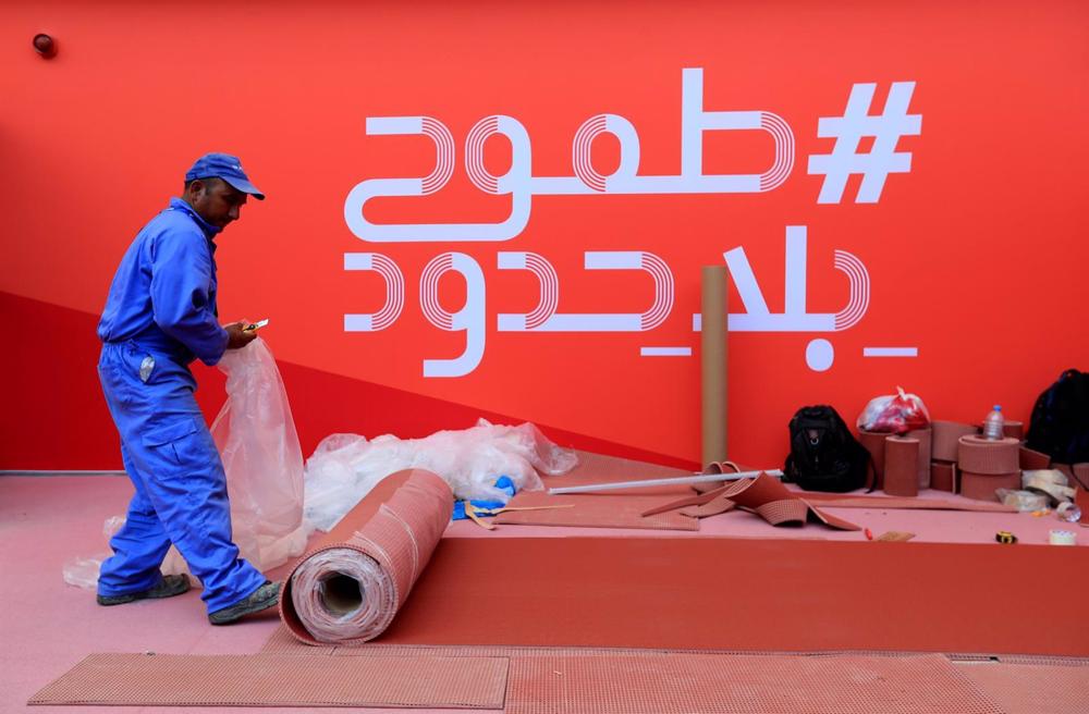 Archive - A worker rolls out a carpet in Qatar Archive