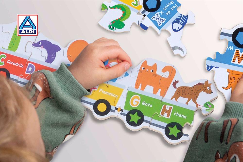 Niño jugando con un puzzle de Aldi. Niño