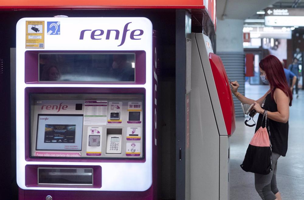 Archivo - Una mujer compra su billete en las taquillas de venta automática de la estación de tren de Atocha, a 1 de septiembre de 2022, en Madrid (España). Archivo