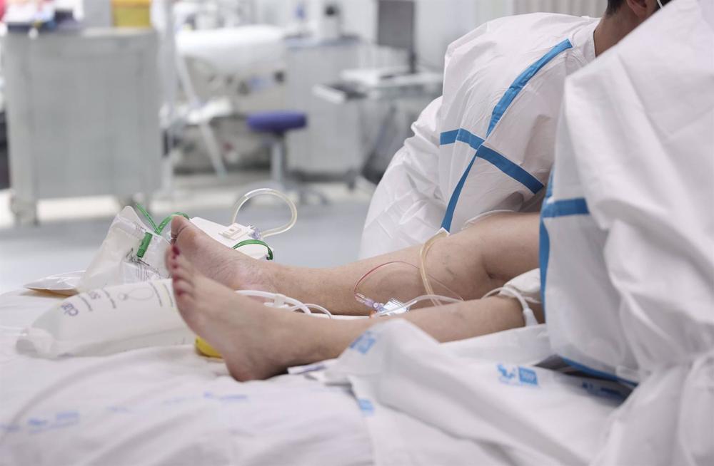 Archivo - Dos enfermeros atienden a una paciente hospitalizada Archivo