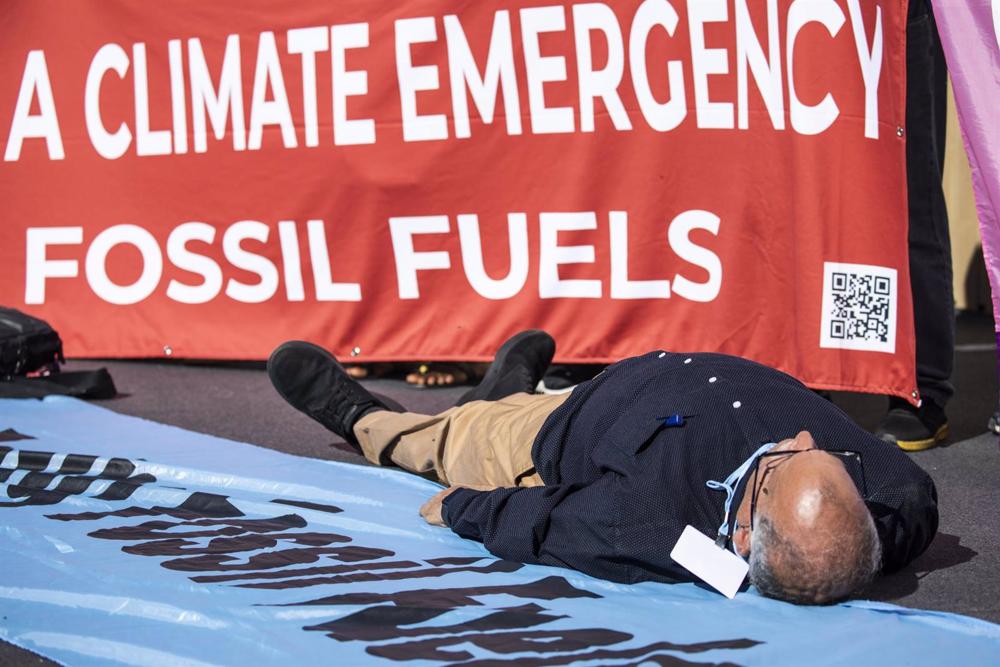11 November 2022, Egypt, Sharm El-Sheikh: A Climate activist lies on the ground as he takes part in a protest against fossil fuels during the 2022 United Nations Climate Change Conference COP27. Photo: Gehad Hamdy/dpa 11