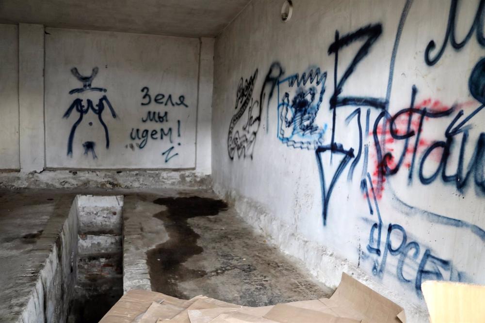 Graffiti cubre la pared en un centro de detención preventiva donde las tropas rusas establecieron una cámara de tortura Graffiti