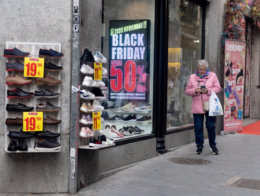 Una mujer pasa por delante de una tienda que anuncia un cartel publicitario del ‘Black Friday’ Una