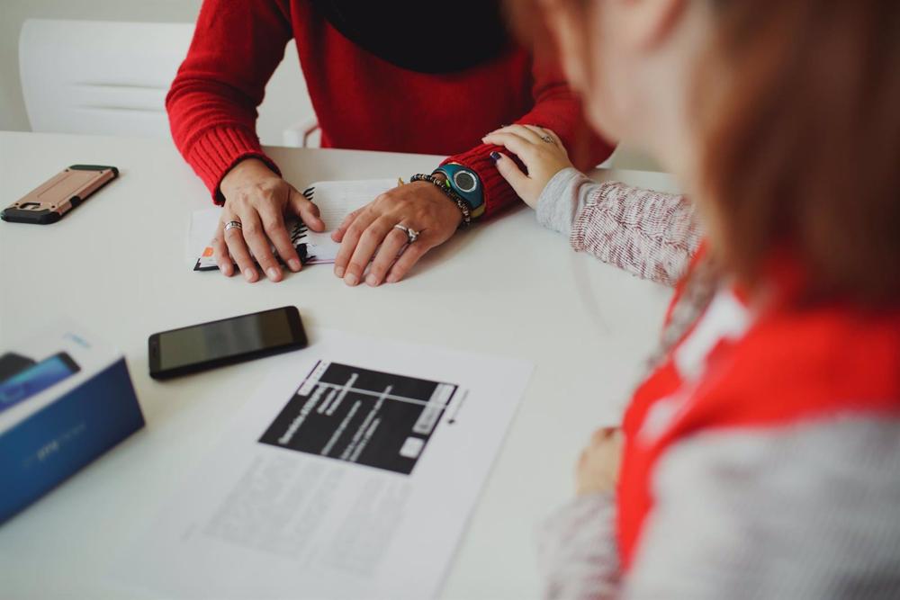 Una trabajadora de Cruz Roja acompaña a una mujer. Una