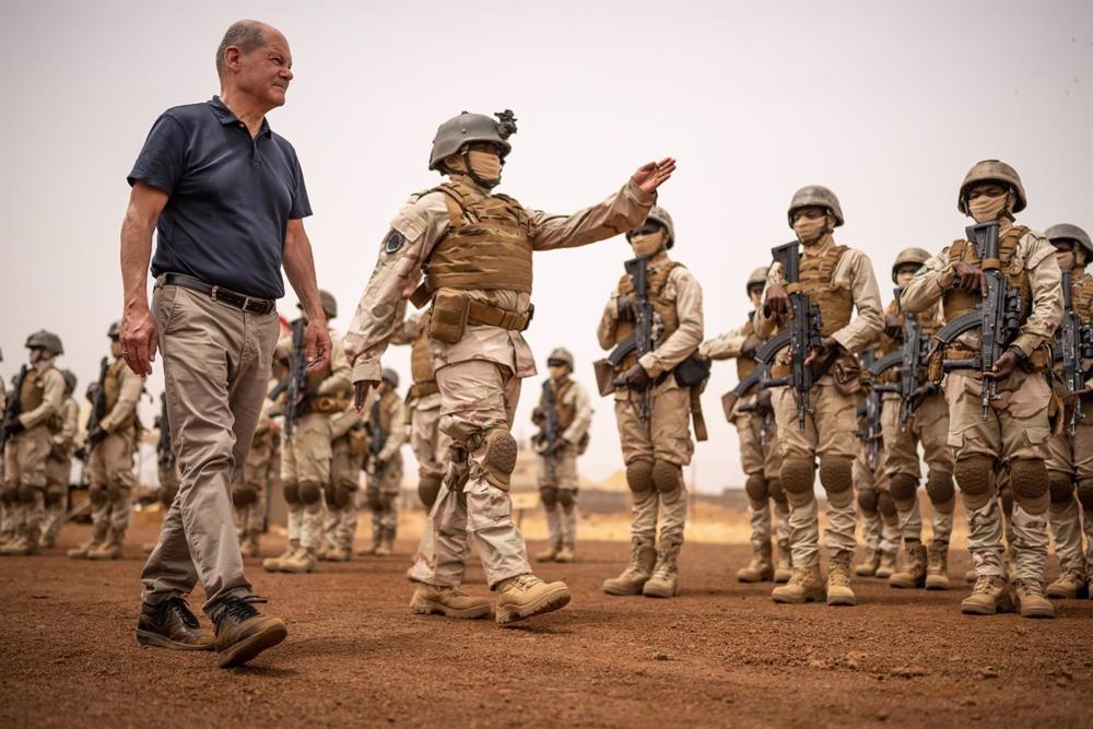 Archiv - Bundeskanzler Olaf Scholz geht bei einem Besuch des Gazelle-Stützpunktes der Joint Task Force Special Operations EUTM Mali der Bundeswehr in Tillia, Niger, vor der nigerianischen Armeeformation. Archiv