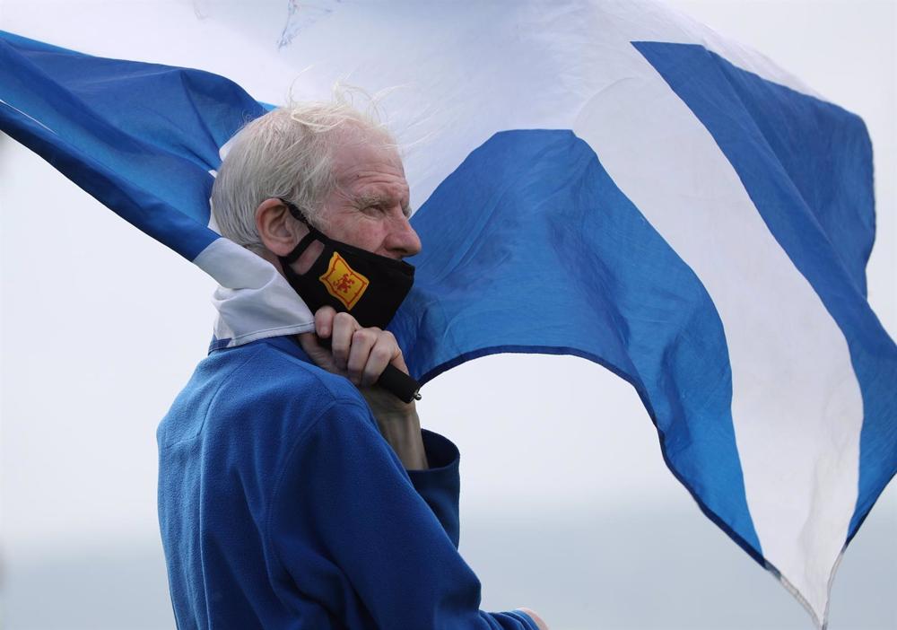 File - A masked man carrying the Scottish flag during a pro-independence demonstration. File