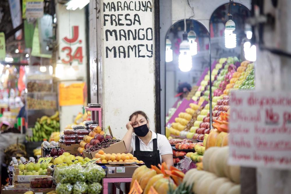 Archivo - Una mujer en un puesto de frutas en un mercado en México Archivo