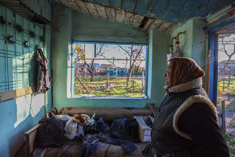 Anna, a 67-year-old Ukrainian woman, reacts as she examines her house damaged by Russian artillery attacks in a village in Kherson region, Ukraine. Anna,