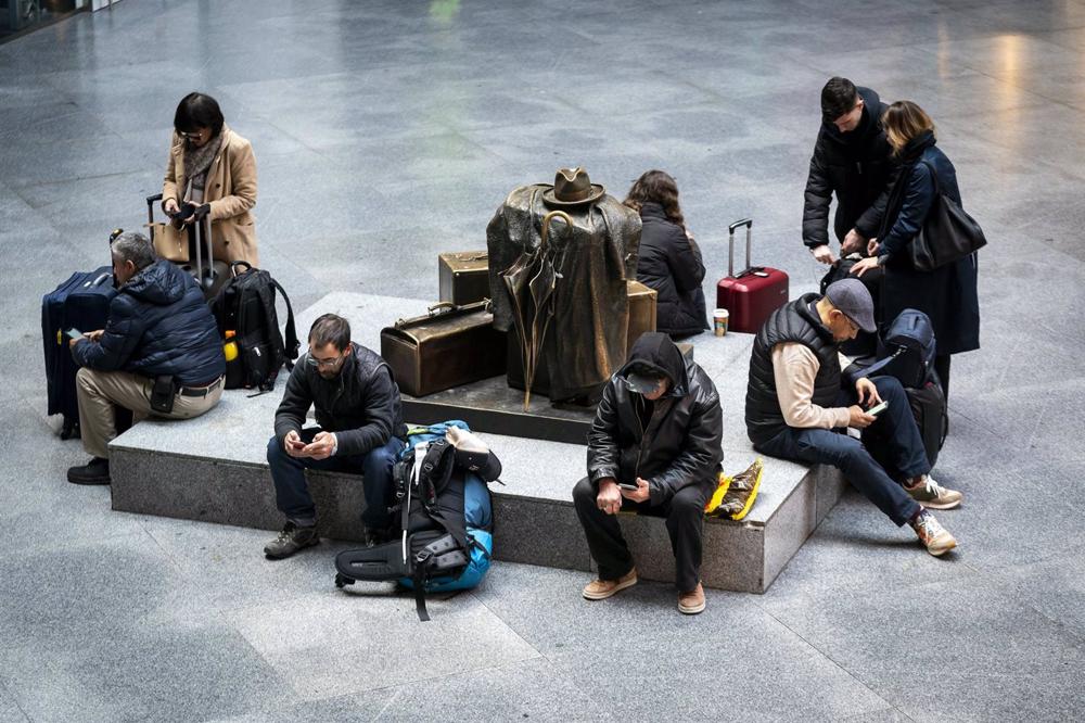 Varias personas con maletas esperan en la estación Puerta de Atocha-Almudena Grandes Varias