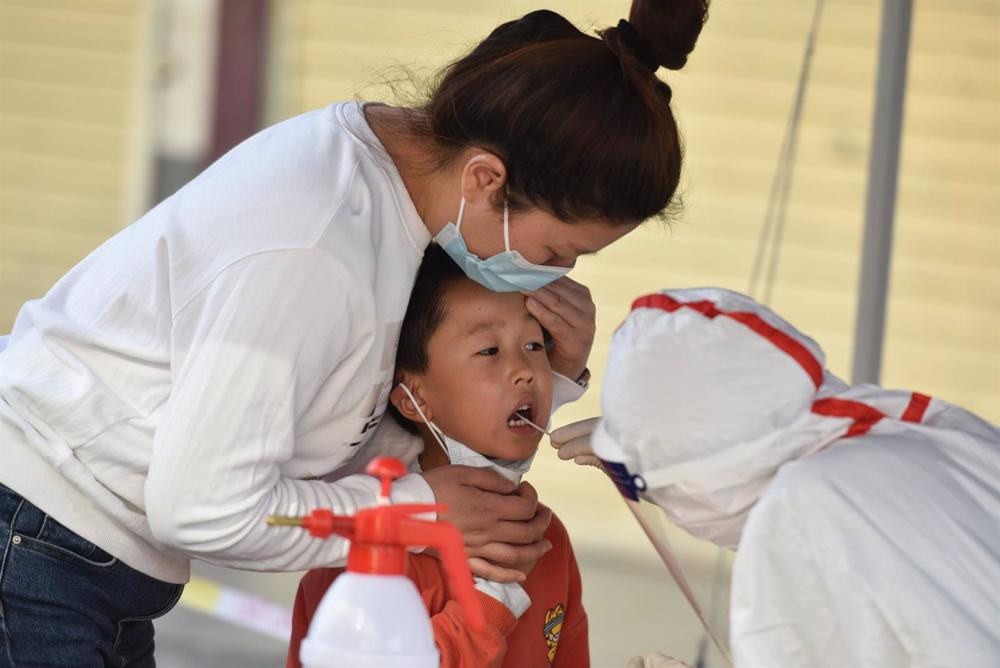 Archive - A health worker collects COVID-19 samples from a child, Fuyang, China. Archive