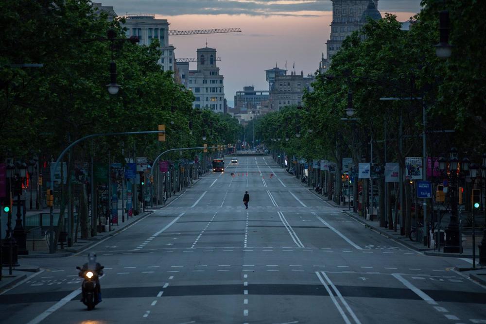 Archivo - Una persona camina por el Paseo de Gràcia de Barcelona que amanece vacío un día de confinamiento. En Barcelona, Cataluña, (España). Archivo