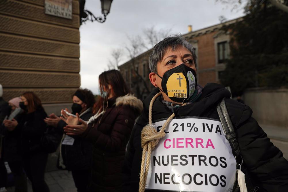 Archivo - Una mujer sostiene una pancarta mientras lleva una cuerda atada al cuello durante una protesta de profesionales de peluquería y estética, frente al Senado, a 9 de diciembre de 2021, en Madrid (España). Durante la protesta, trabajadores y trabaja Archivo
