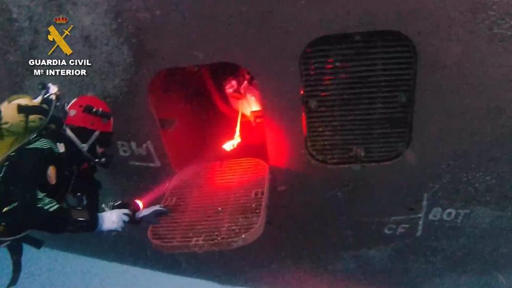 Buzos del GEAS inspeccionan el casco del buque Buzos