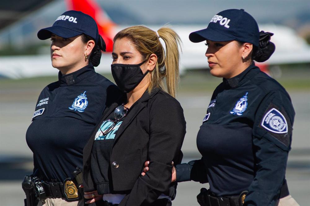 Nini Johana Usuga. Alias 'La Negra', escorted by two Colombian police officers. Nini