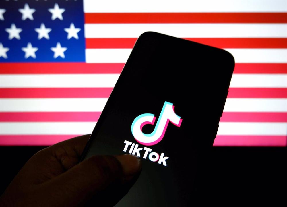 Archivo - Logotipo de TikTok sobre un fondo con la bandera de Estados Unidos. Archivo