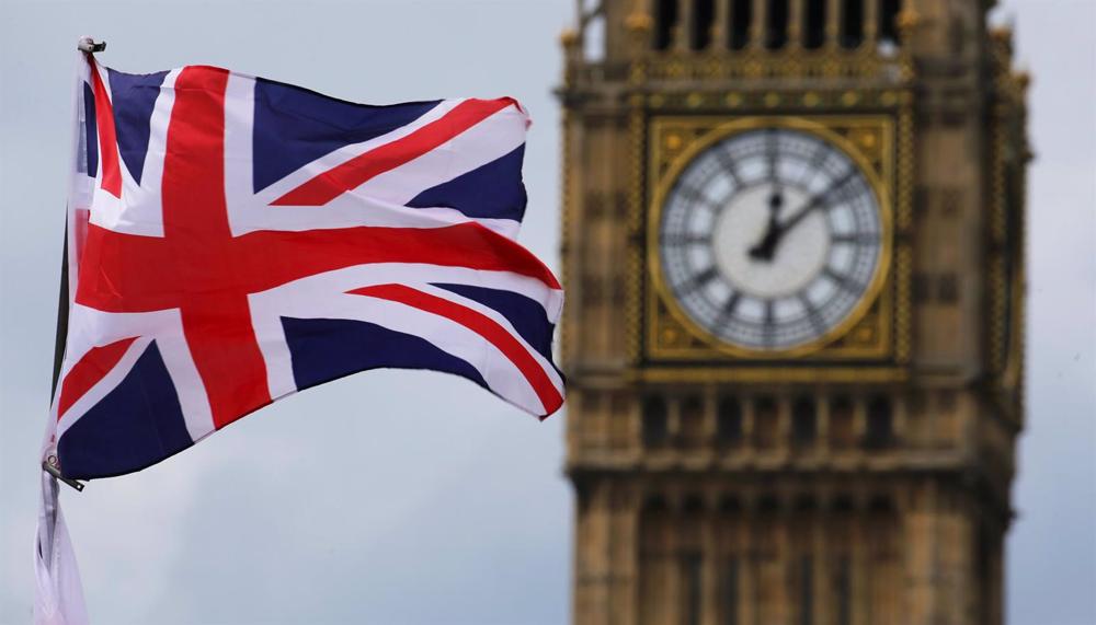 Archivo - FILED - 24 June 2016, United Kingdom, London: The British Union Jack, flies in front of the Big Ben, the clock face of the Elizabeth Tower. The refurbishment of London's Big Ben tower and clock will be finished next year, the British parliament Archivo
