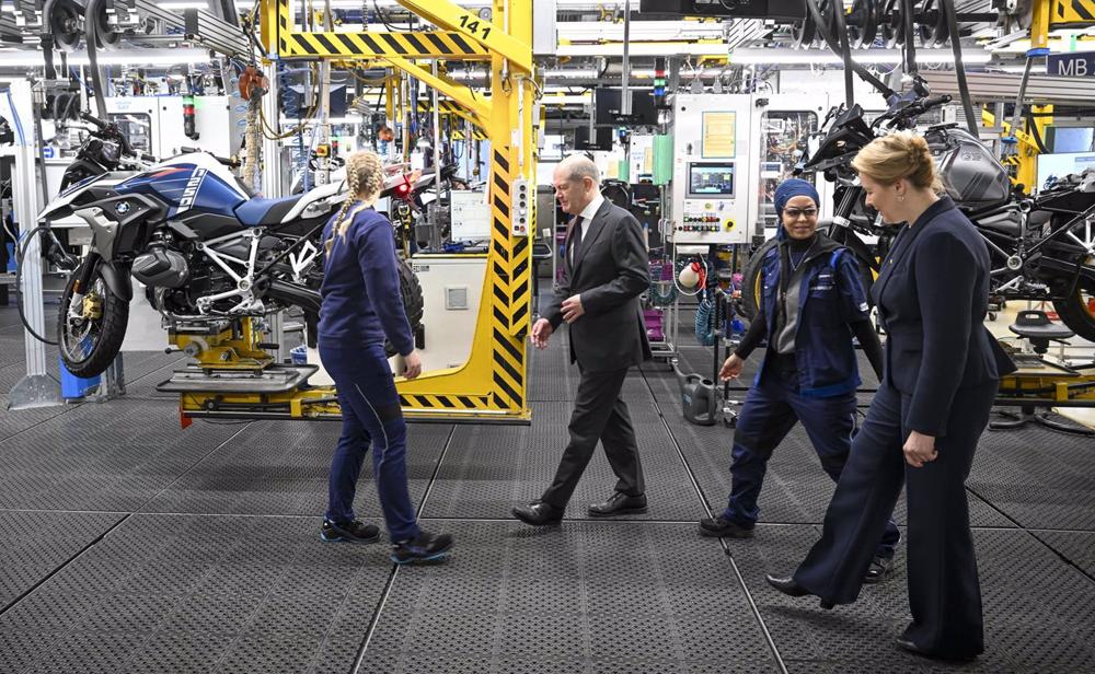 19 December 2022, Berlin: German Chancellor Olaf Scholz (2nd L), and Berlin's Governing Mayor Franziska Giffey (R) meet apprentices during a visit to the BMW Group motorcycle plant in Spandau. Photo: Jens Kalaene/dpa 19