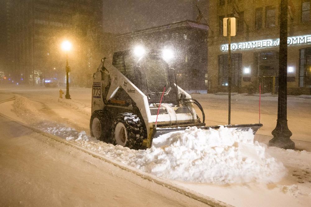 Una minipala sgombera la neve davanti alla Ohio State House mentre una forte tempesta invernale porta temperature sotto lo zero negli Stati Uniti. Una