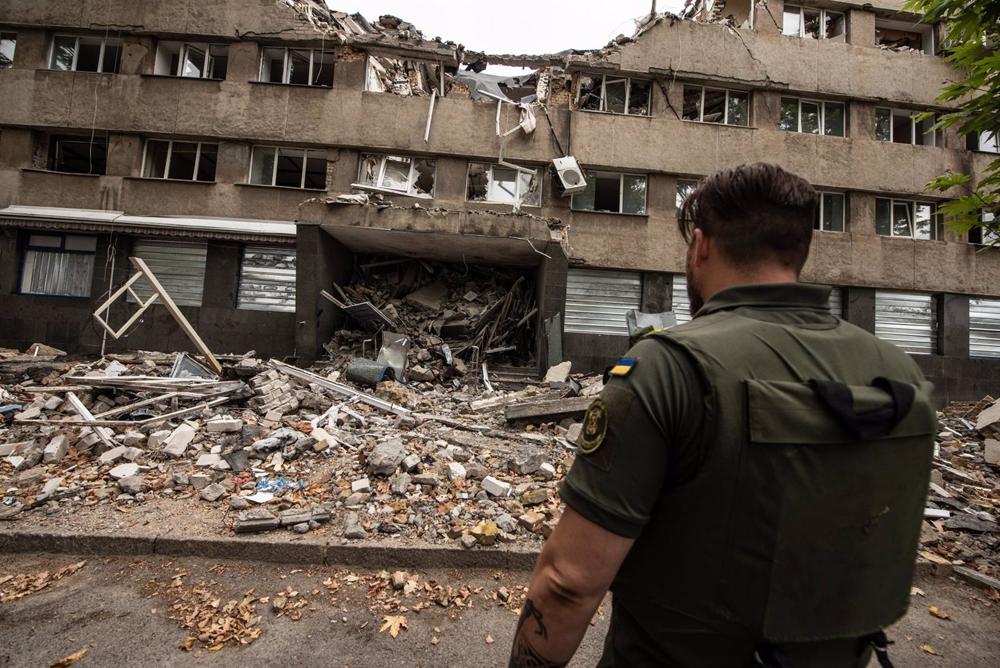 Archivo - Un soldado ucraniano frente a un edificio bombardeado. Archivo