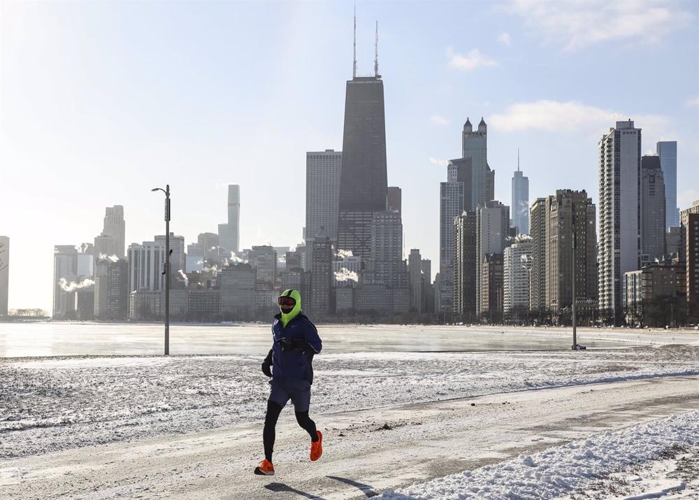 Un uomo corre lungo la spiaggia di North Ave a Chicago, negli Stati Uniti, il 24 dicembre 2022. Un