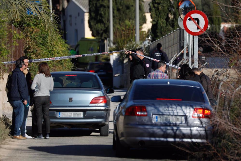 Un policía sostiene el precinto en las inmediaciones de la casa Un