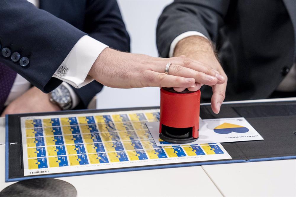 Archivo - Varias manos pulsan el sello ‘España con Ucrania’ Archivo