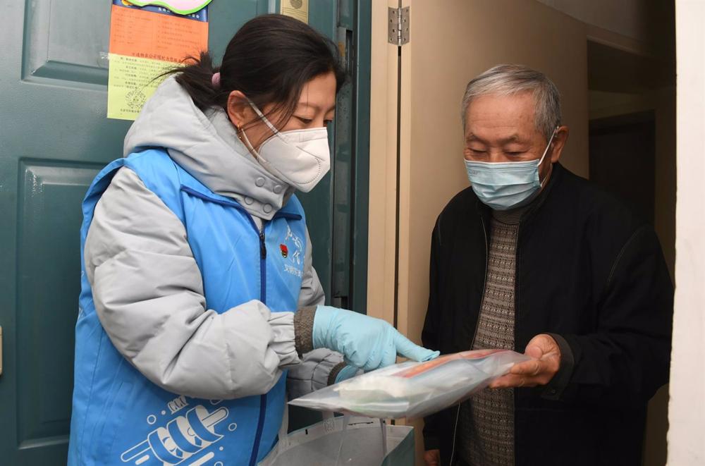 A worker delivers an aid package in Beijing's Haidian district. A