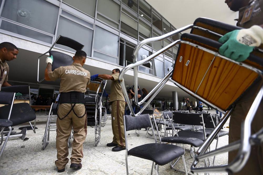 Varios trabjadores realizan labores de limpieza en dependencias asaltadas el domingo en Brasilia. Varios
