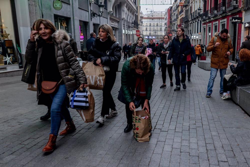 Varias personas caminan con bolsas de las rebajas en la calle Preciados, a 7 de enero de 2022, en Madrid (España) Varias