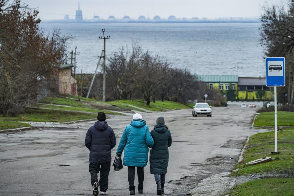 Arquivo - As pessoas passeiam pela cidade de Nikopol nas margens do rio Dnieper com a central nuclear de Zaporiyia como pano de fundo. Arquivo