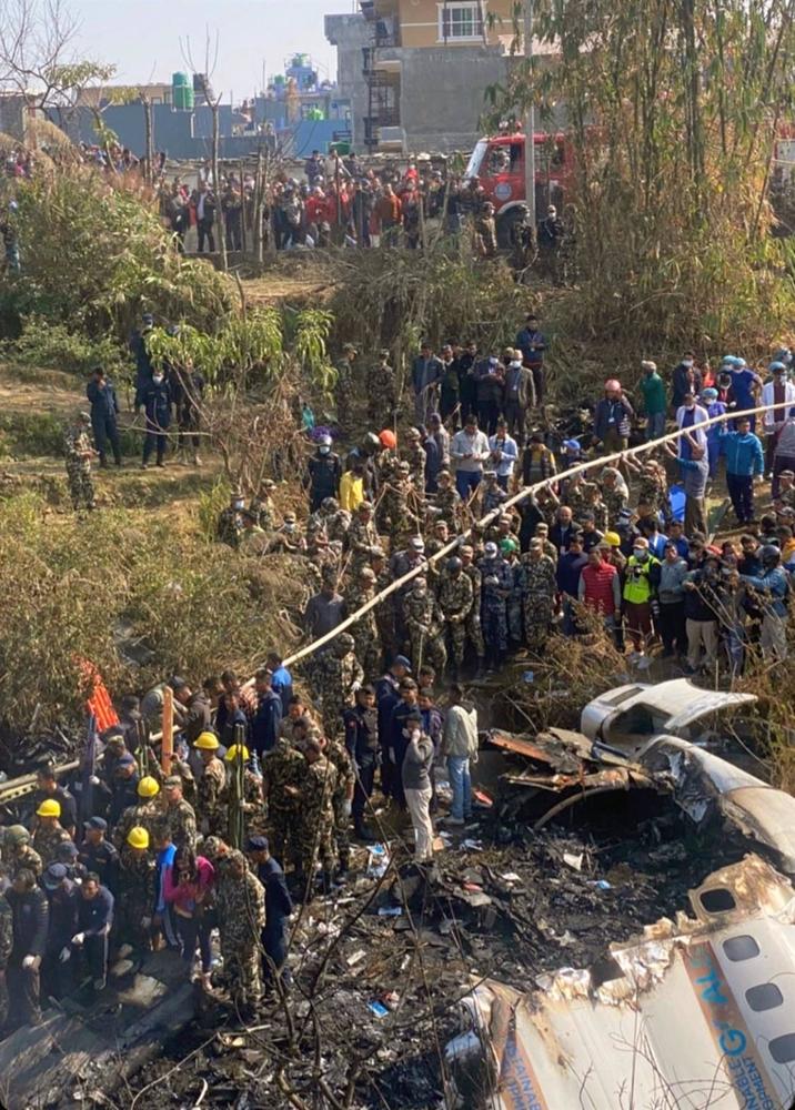 Mitglieder des Rettungsteams und die Öffentlichkeit versammeln sich an der Absturzstelle eines ATR72-Flugzeugs der Yeti Airlines mit 72 Menschen an Bord in Pokhara, Westnepal. Mitglieder