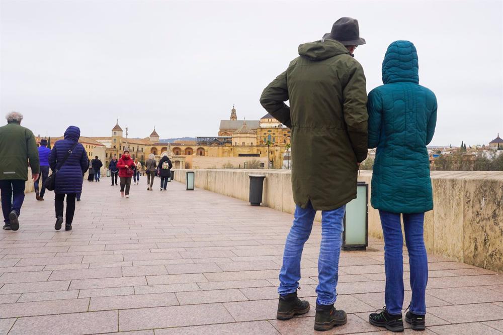 Transeúntes y turistas por el famoso puente de San Rafael con vistas a la Mezquita . Transeúntes
