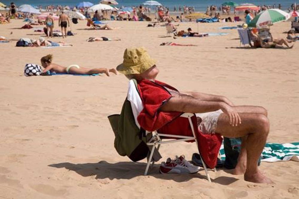 Un hombre toma el sol en una playa. Un