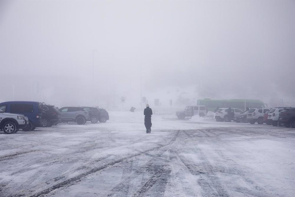 Una persona camina por la nieve en el parking del Puerto de Navacerrada, a 19 de enero de 2023, en Navacerrada, Madrid (España). La Agencia de Seguridad y Emergencias de la Comunidad de Madrid (ASEM 112) ha activado la situación 0 de la fase de alerta del Una
