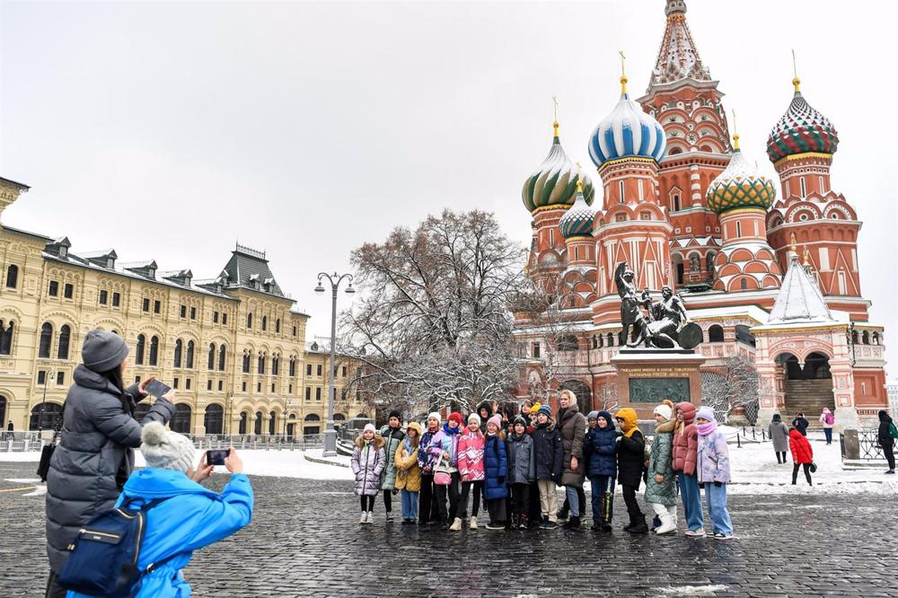 Un grupo posa para una foto en la plaza Roja de Moscú, frente a la catedral de San Basilio Un