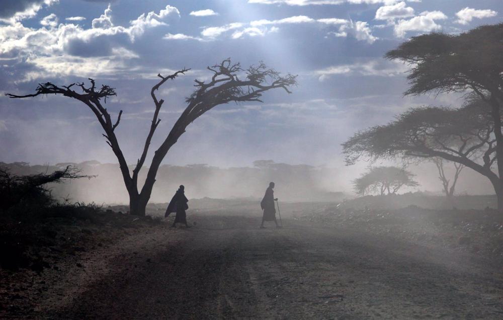 Arquivo - Dois Maasai atravessam uma estrada no Parque Nacional do Serengeti, na Tanzânia. Arquivo