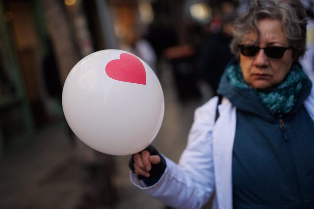 Una mujer con un globo con un corazón participa en una manifestación por la Atención Primaria Una