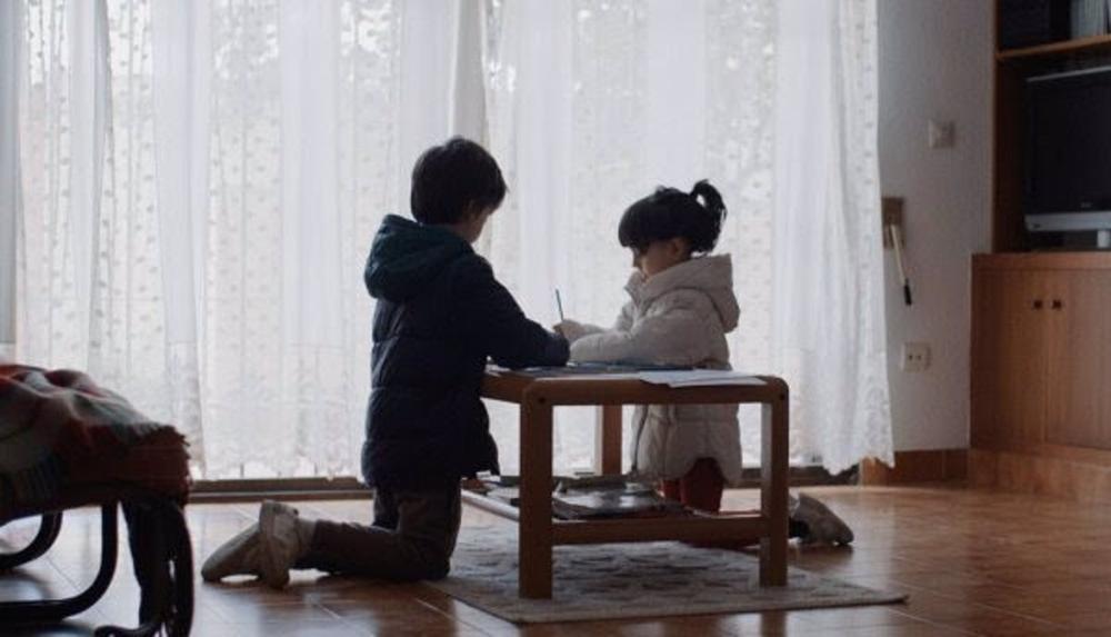 Niños con abrigo en casa al carecer de recursos para mantener una temperatura adecuada en invierno. Niños