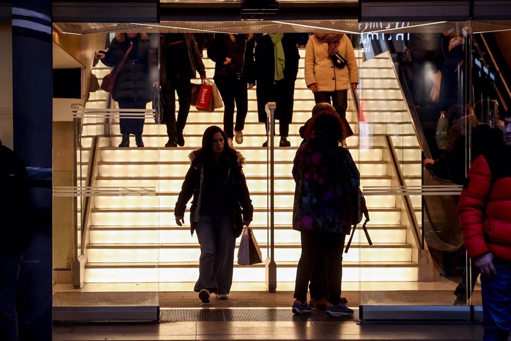 Varias personas entran y salen de un establecimiento comercial el primer día de las rebajas de enero Varias