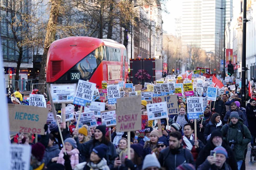 Manifestantes marcham através de Londres em direcção a Downing Street durante a greve dos enfermeiros contra os Serviços Mínimos durante a Lei de Greve. Manifestantes