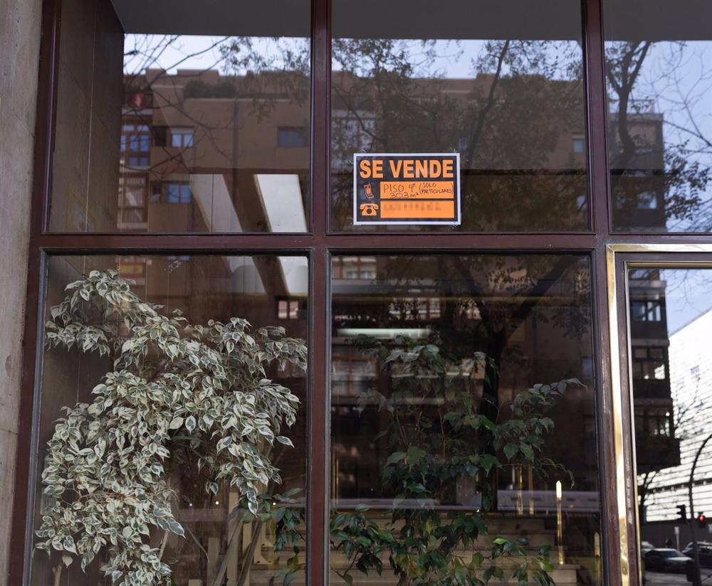 Archivo - Un cartel de 'Se vende piso' en un portal de la ciudad de Madrid Archivo