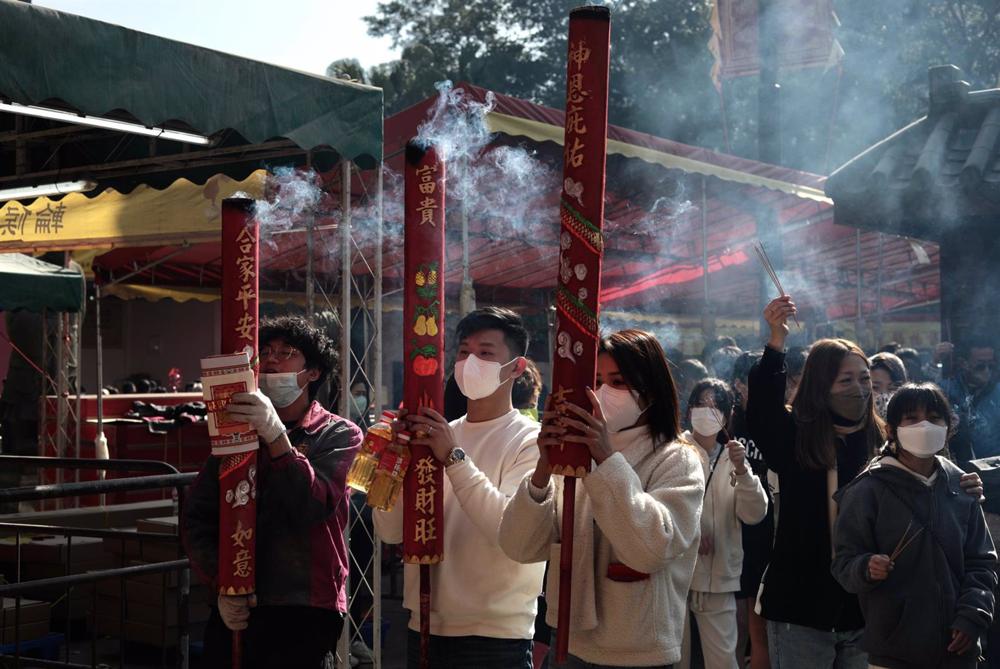 28 January 2023, China, Hong Kong: A couple offer huge incense to the God as a gesture of sincerity at Che Kong Temple during Chinese New Year celebration. Photo: Liau Chung-Ren/ZUMA Press Wire/dpa 28