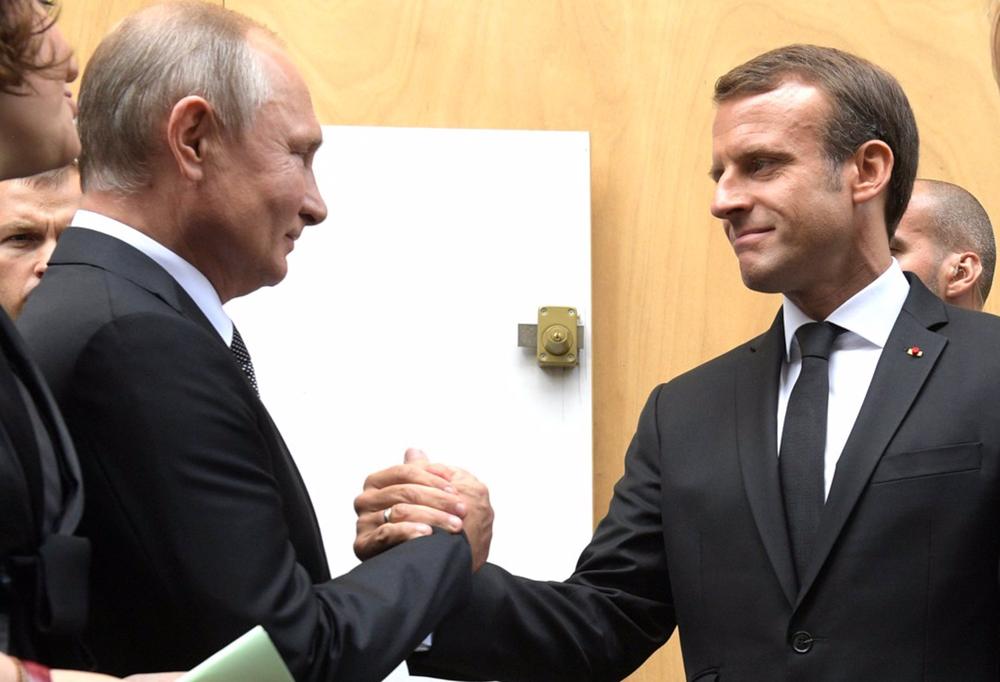 File - Vladimir Putin and Emmanuel Macron greet each other (file photo). File