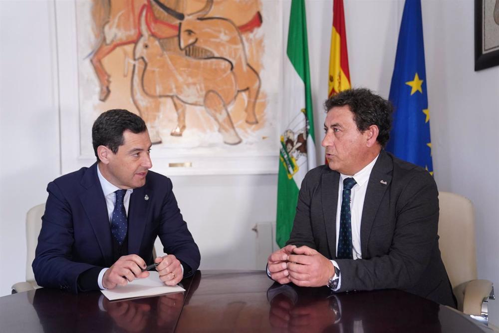 El presidente de la Junta de Andalucía, Juanma Moreno (i), con el alcalde de Cazalla de la Sierra (Sevilla), Sotero Martín, en el transcurso de una visita al municipio. El