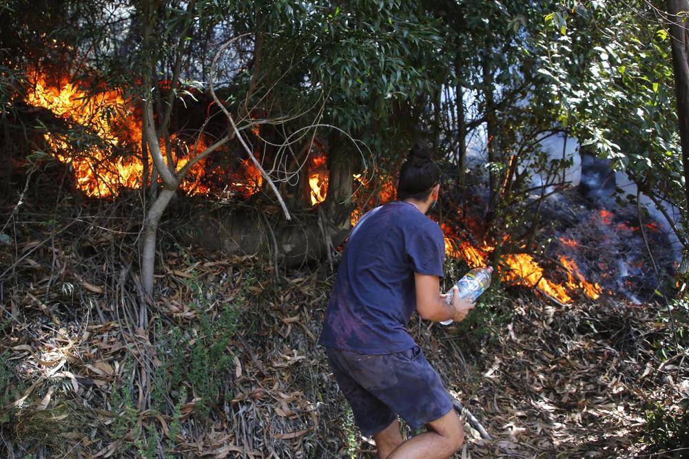 Vecinos y un grupo de militares controlan un sector de los incendios forestales en Dichato, Chile Vecinos