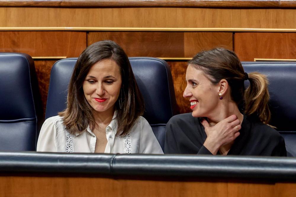 La ministra de Derechos Sociales y Agenda 2030, Ione Belarra (i), y la ministra de Igualdad, Irene Montero (d), conversan durante una sesión plenaria en el Congreso de los Diputados, a 7 de marzo de 2023, en Madrid (España). La